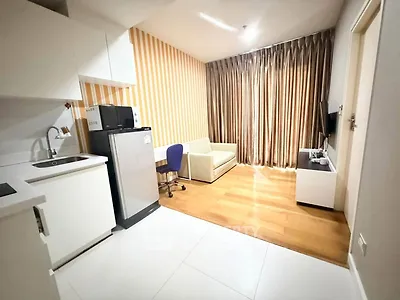Modern studio apartment with kitchenette and cozy living area, featuring stylish decor and natural light.