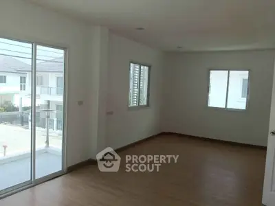 Spacious empty room with large windows and balcony access in modern home