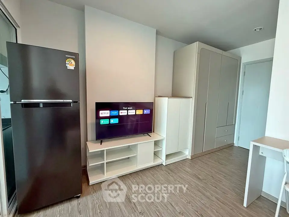 Modern living room with sleek furniture and smart TV, featuring a spacious wardrobe and stylish flooring.