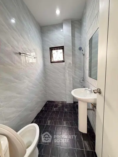 Modern bathroom with sleek design and natural light, featuring elegant fixtures and stylish tile flooring.