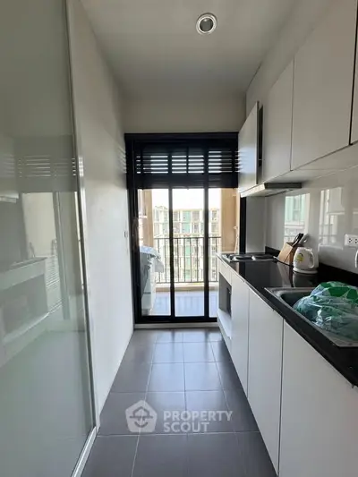 Modern kitchen with sleek cabinets and balcony view