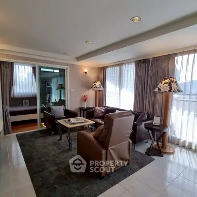 Spacious living room with elegant leather furniture and large windows for natural light.