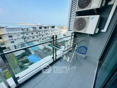 Charming balcony with city and sea view, featuring air conditioning units and drying rack.