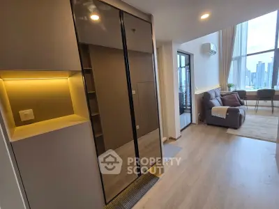 Modern living room with sleek design and city view, featuring a cozy sofa and stylish lighting.