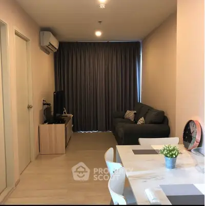 Modern living room with cozy sofa and dining area, featuring elegant decor and natural light.