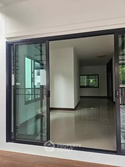 Spacious modern interior with large sliding glass doors and tiled flooring, perfect for natural light.