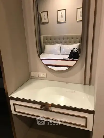 Elegant bedroom with stylish vanity mirror and plush headboard, perfect for modern living.