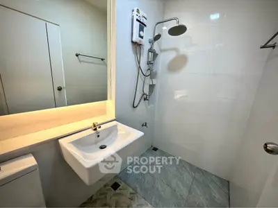 Modern bathroom with sleek fixtures and wall-mounted shower in a contemporary apartment.