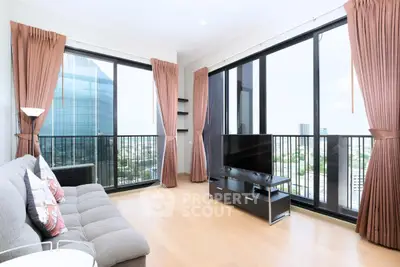 Spacious modern living room with floor-to-ceiling windows and city view, featuring elegant curtains and sleek furniture.