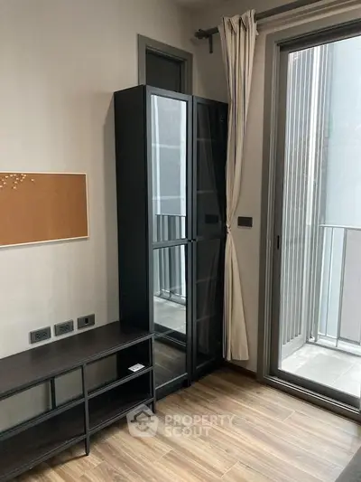 Modern apartment interior with sleek furniture and balcony access, featuring stylish flooring and ample natural light.