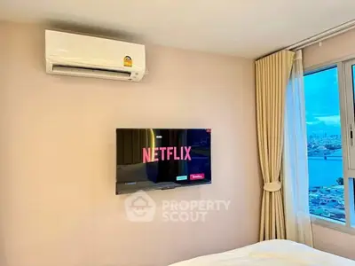 Modern bedroom with wall-mounted TV and air conditioning, offering a cozy and comfortable living space.