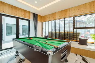 Luxurious game room with pool table and large windows in modern home