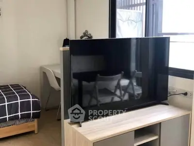 Modern studio apartment with sleek TV setup and cozy workspace