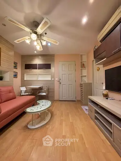 Modern living room with stylish furniture and wooden flooring, featuring a ceiling fan and wall-mounted TV.