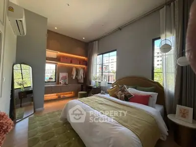 Stylish bedroom with modern decor and large windows offering natural light.