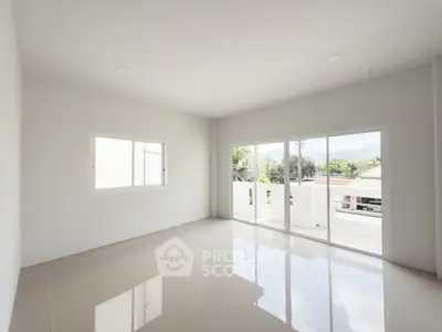 Spacious and bright living room with large windows and glossy tiled floors.
