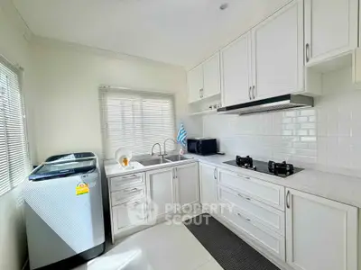 Bright modern kitchen with gas stove and washing machine