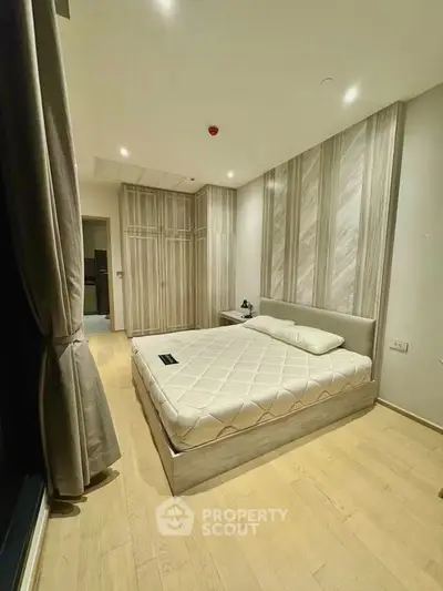Modern bedroom with stylish decor and ample natural light, featuring a comfortable bed and elegant wardrobe.