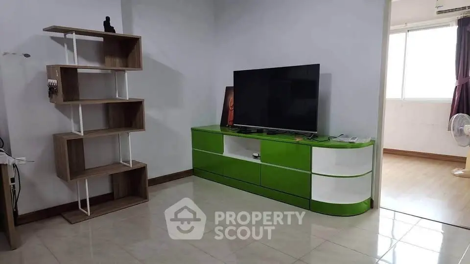 Modern living room with sleek green TV stand and open shelving unit, bright and inviting space.
