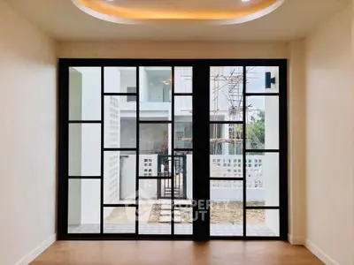 Modern interior with large glass doors and outdoor view, showcasing contemporary design.