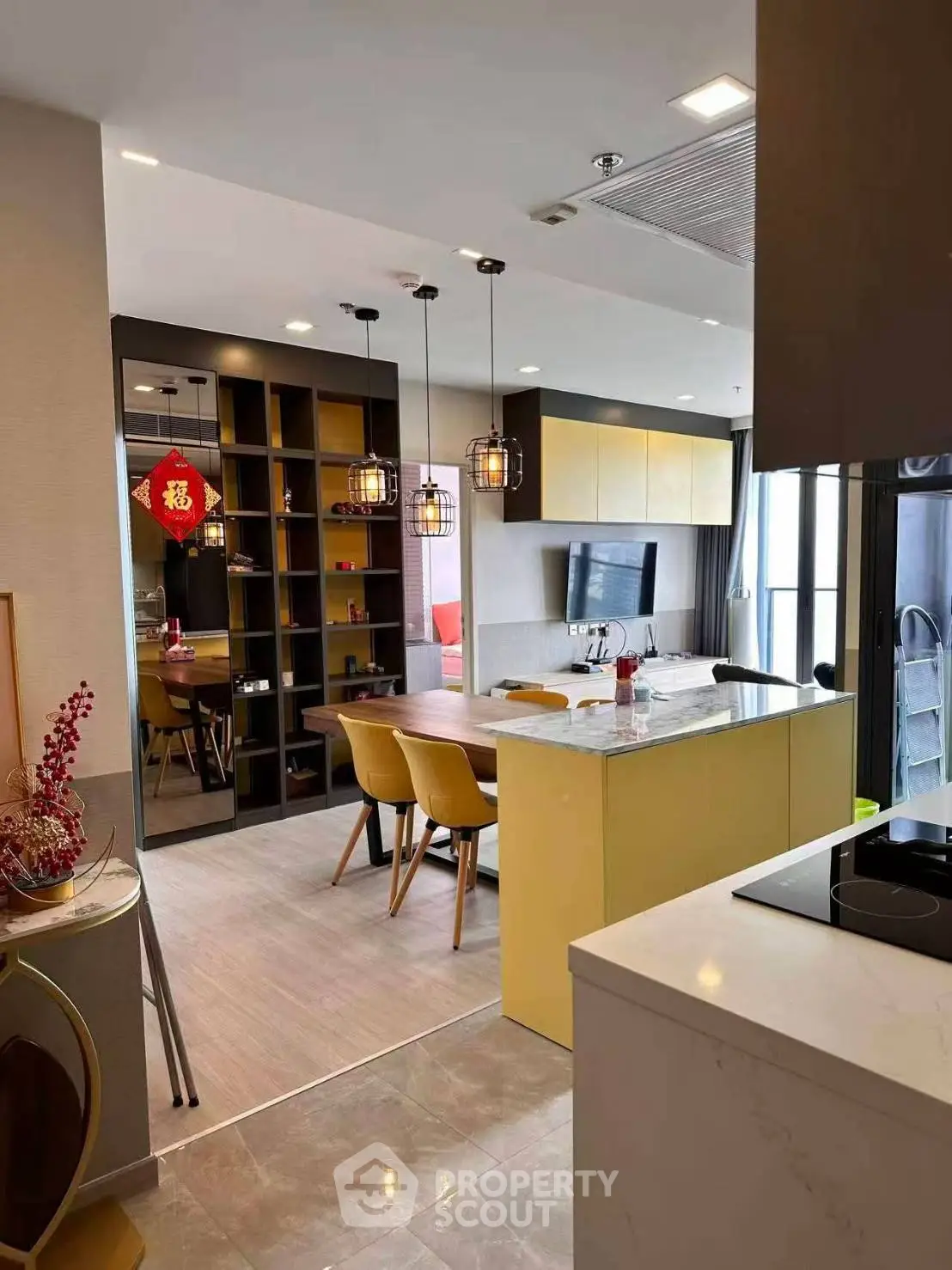 Modern open-layout kitchen with stylish dining area and contemporary lighting.