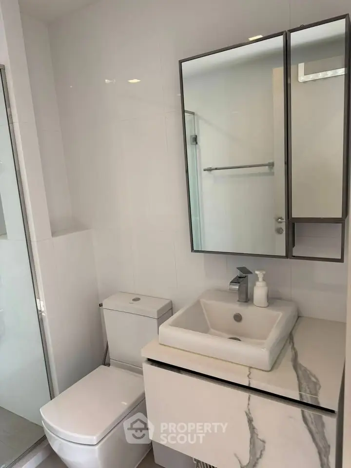 Modern bathroom with sleek vanity and glass shower enclosure