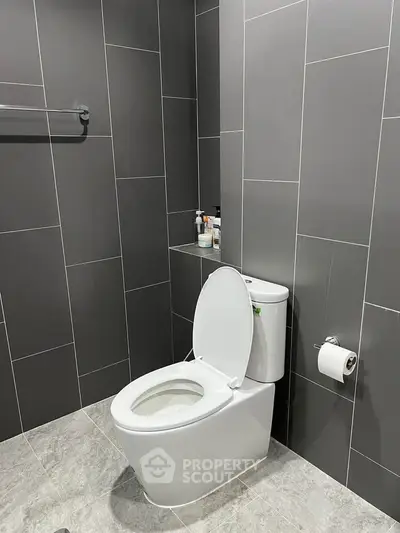 Modern bathroom with sleek gray tiles and contemporary toilet design.