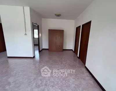 Spacious empty room with wardrobe and tiled flooring, ideal for customization.