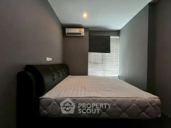 Modern bedroom with minimalist decor and air conditioning unit.