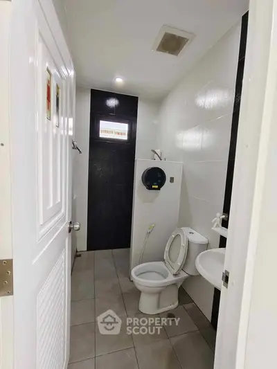 Modern bathroom with sleek design and efficient layout, featuring a compact toilet and sink.