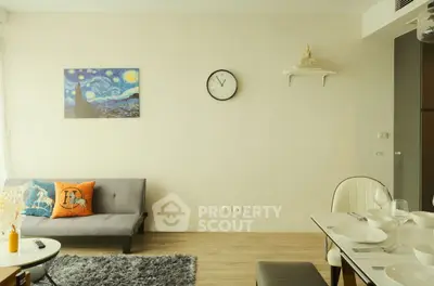 Modern living room with stylish decor and dining area, featuring a cozy sofa and elegant wall art.