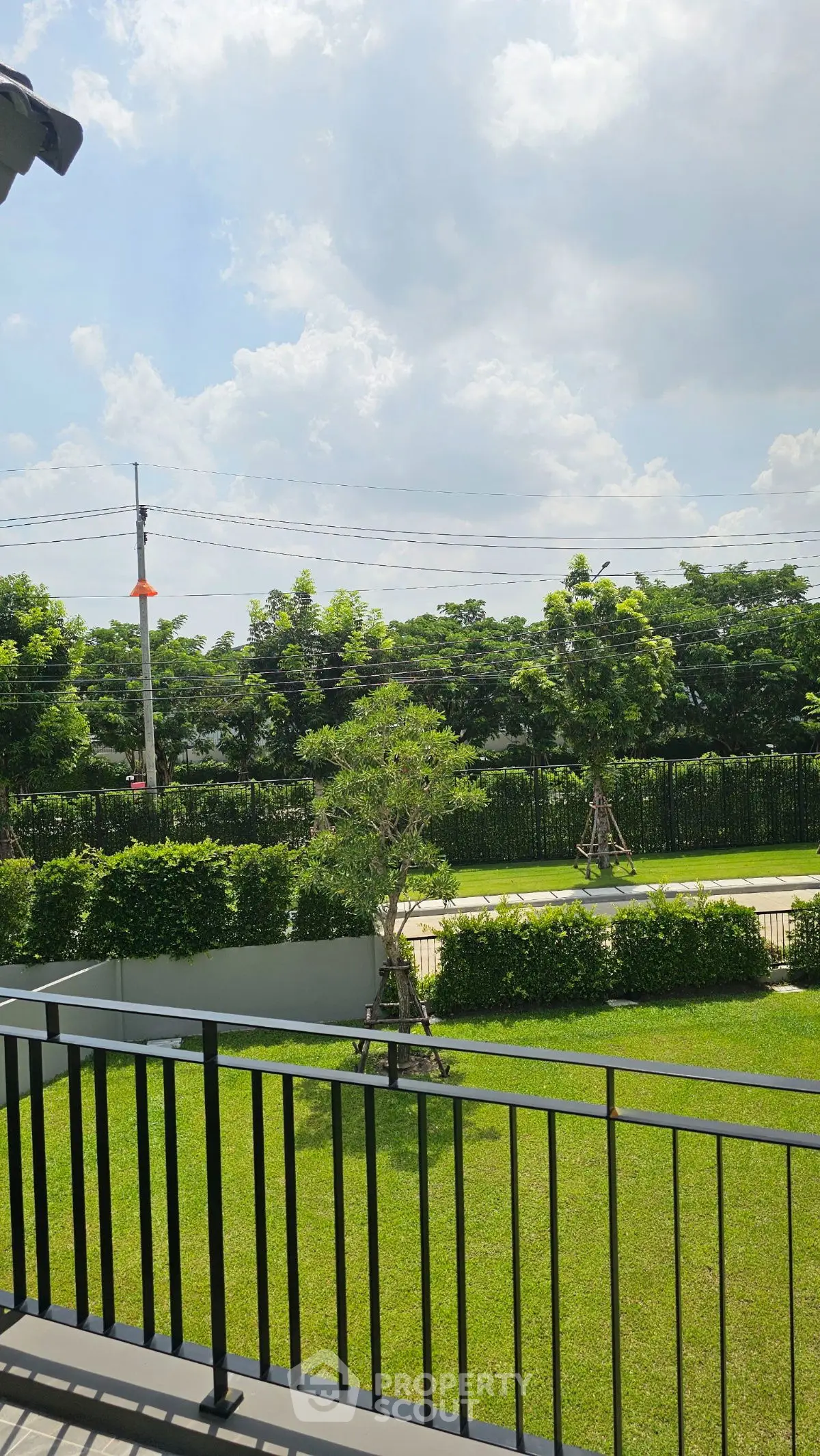 Spacious garden view from a modern balcony, perfect for relaxation and outdoor enjoyment.