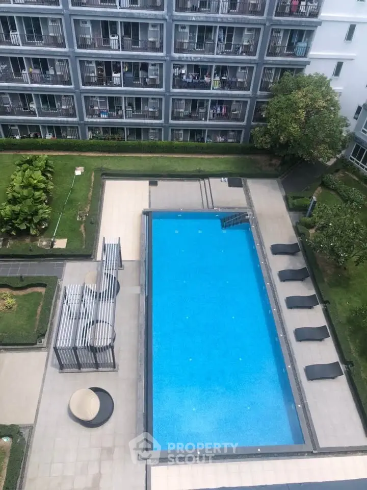 Stunning aerial view of modern apartment complex with inviting swimming pool and lush greenery.