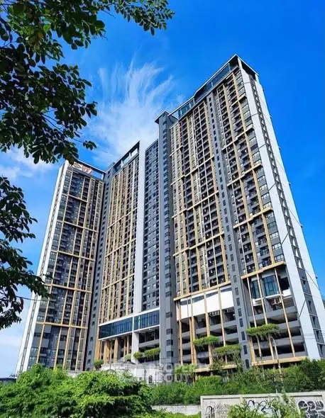 Stunning modern high-rise building with lush greenery and clear blue sky backdrop.