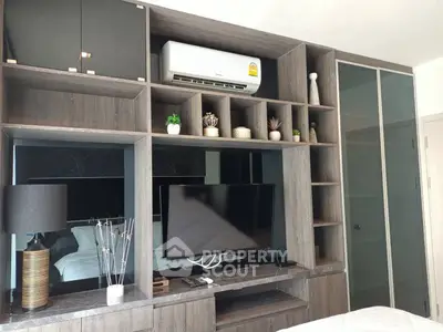 Modern bedroom with stylish shelving, TV, and air conditioning unit, perfect for comfort and relaxation.