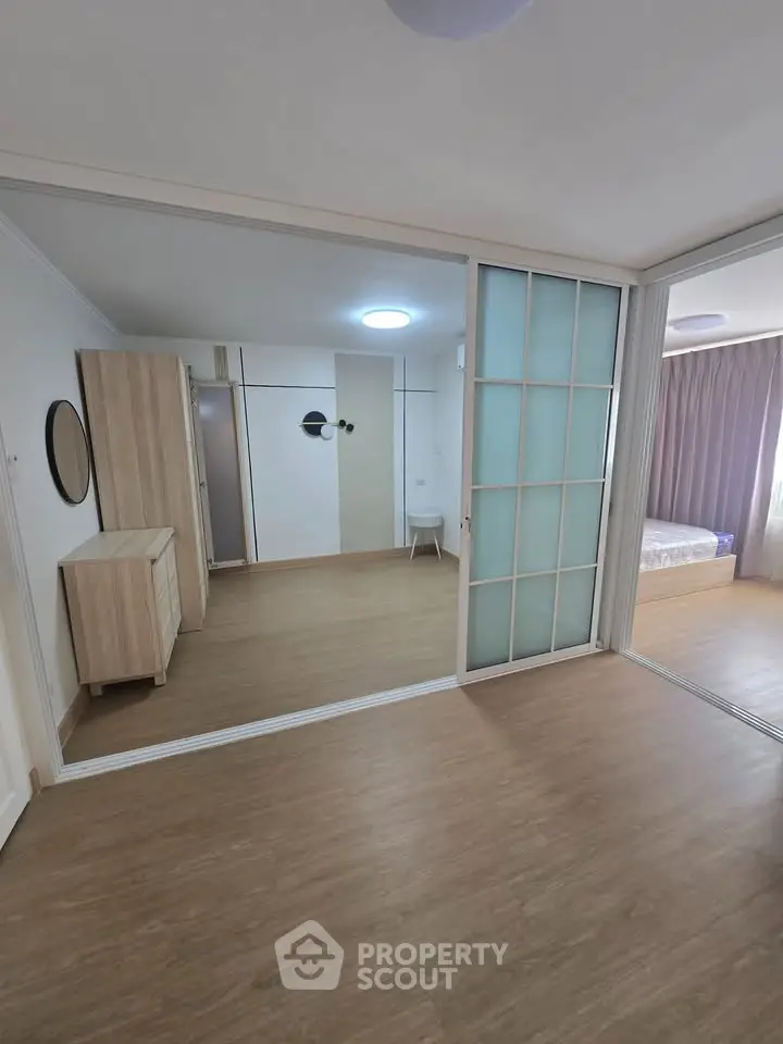 Spacious modern bedroom with sliding glass doors and wooden flooring