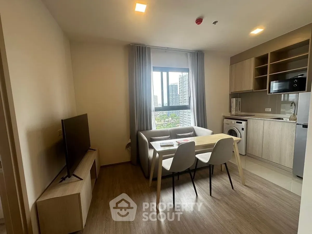 Modern living room with dining area and city view, featuring sleek furniture and natural light.