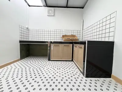 Modern kitchen with black and white tile flooring and sleek cabinetry