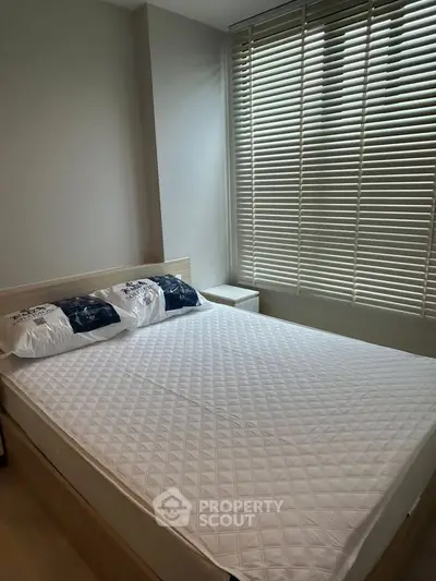 Cozy bedroom with natural light and modern blinds, perfect for relaxation.