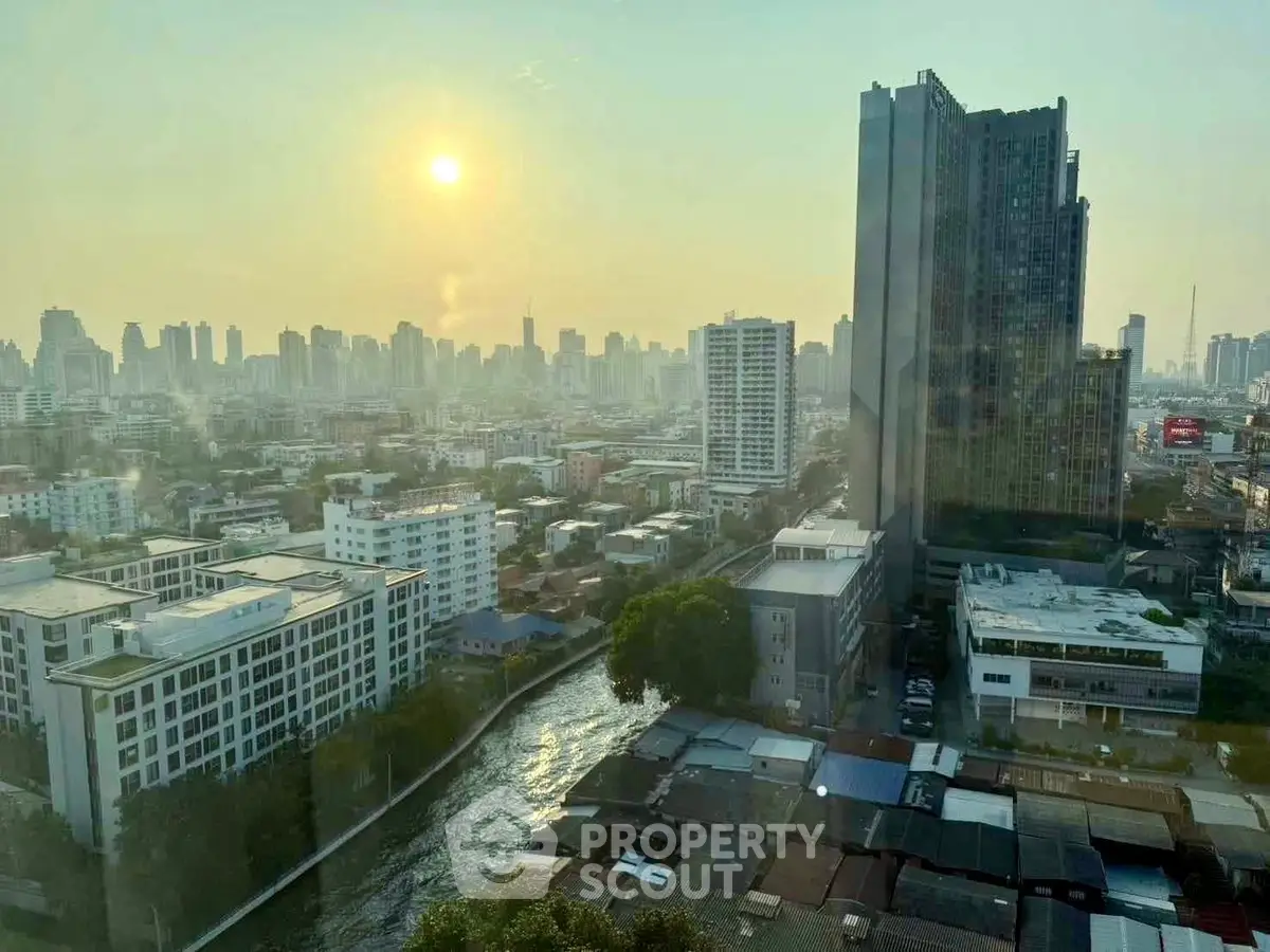 Stunning cityscape view from high-rise building at sunset, showcasing urban skyline and river.