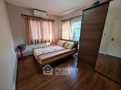 Cozy bedroom with wooden flooring and natural light