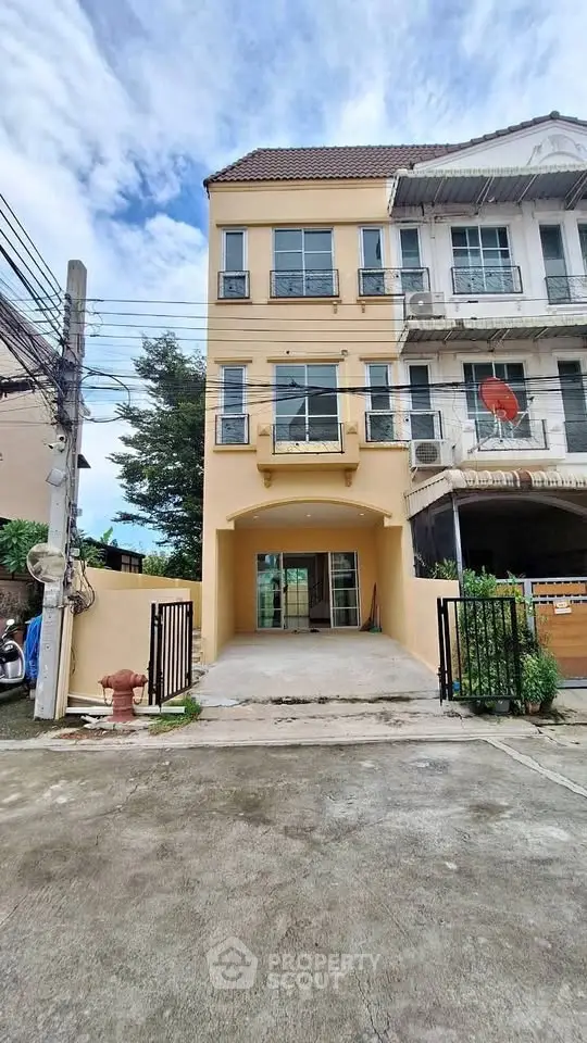 Charming three-story townhouse with gated driveway and modern facade, perfect for urban living.