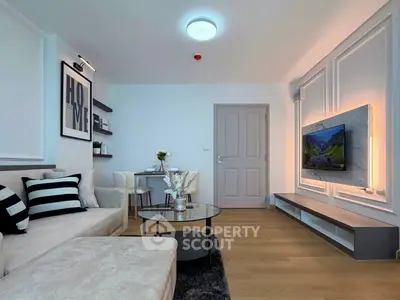 Modern living room with stylish decor and wall-mounted TV, featuring cozy seating and elegant lighting.