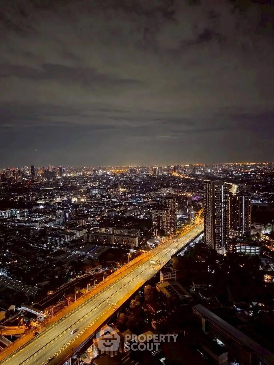 Stunning cityscape view with illuminated highway and skyline at night, perfect for urban living enthusiasts.