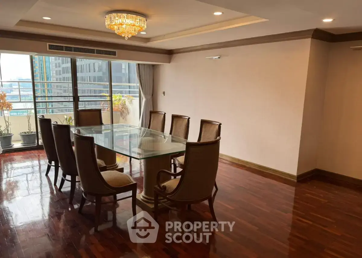 Spacious dining area with elegant glass table and city view balcony in luxury apartment.