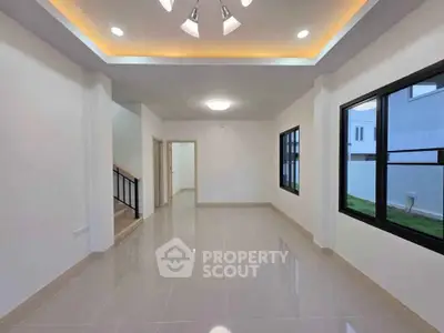 Spacious modern living room with sleek tile flooring and recessed lighting.