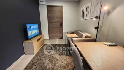 Modern living room with stylish furniture and wall art, featuring a cozy atmosphere and a flat-screen TV.