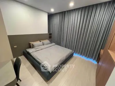 Modern bedroom with sleek design and floor-to-ceiling curtains, featuring a comfortable bed and stylish furnishings.