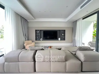 Luxurious modern living room with plush sofa and large TV, perfect for relaxation.