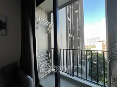 Modern apartment balcony with city view and laundry rack